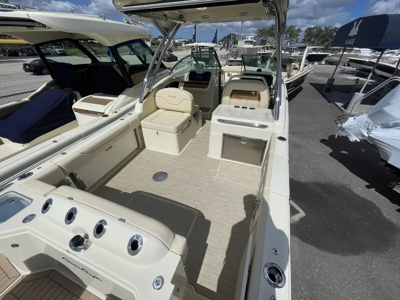 Slide: The Image of 2025 Chris-Craft Calypso 28 boat interior with seating and helm, docked outdoors. - 4