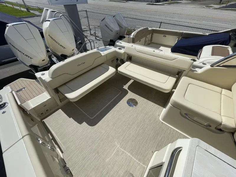 Slide: The Image of 2025 Chris-Craft Calypso 28 boat interior with beige seating and twin outboard engines. - 6