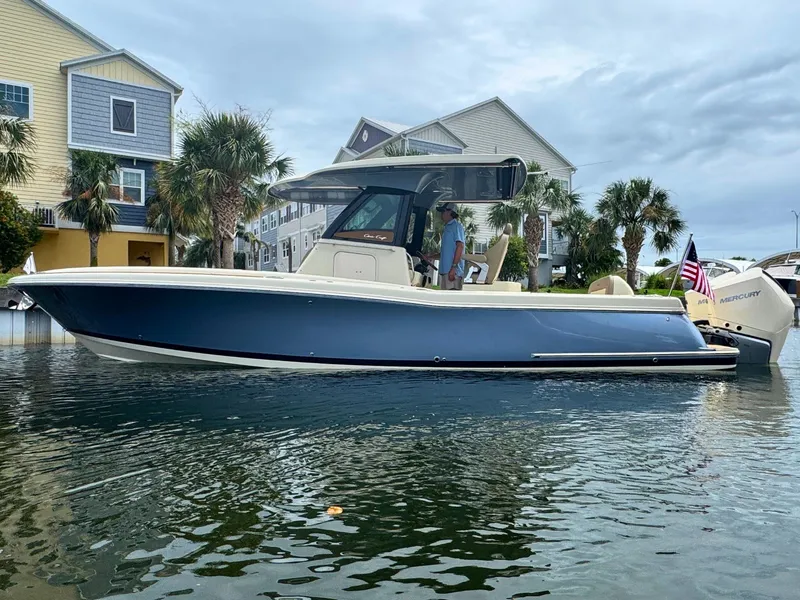 Slide: The Image of 2025 Chris-Craft Catalina 30 boat docked near waterfront homes, featuring sleek design and modern amenities. - 0