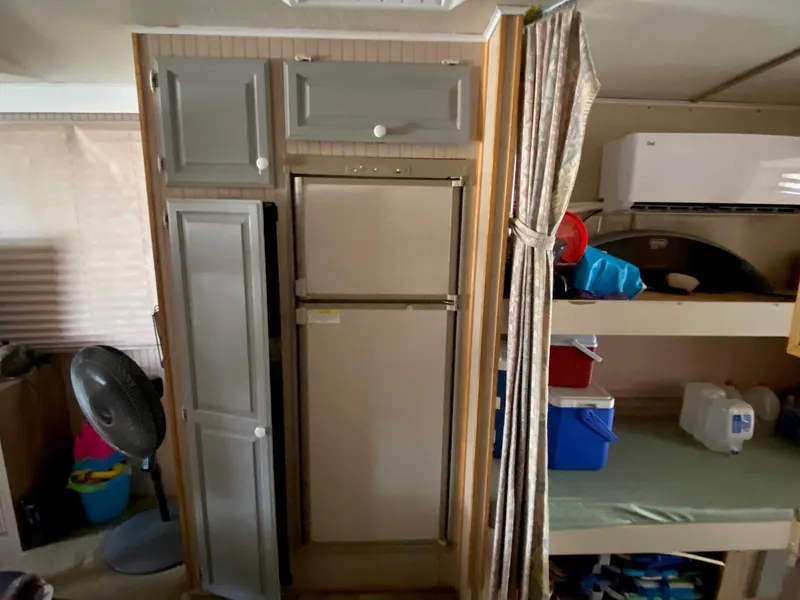 Slide: The Image of 1988 Boatel Hercules interior with fridge, cabinets, and bunk beds. - 13