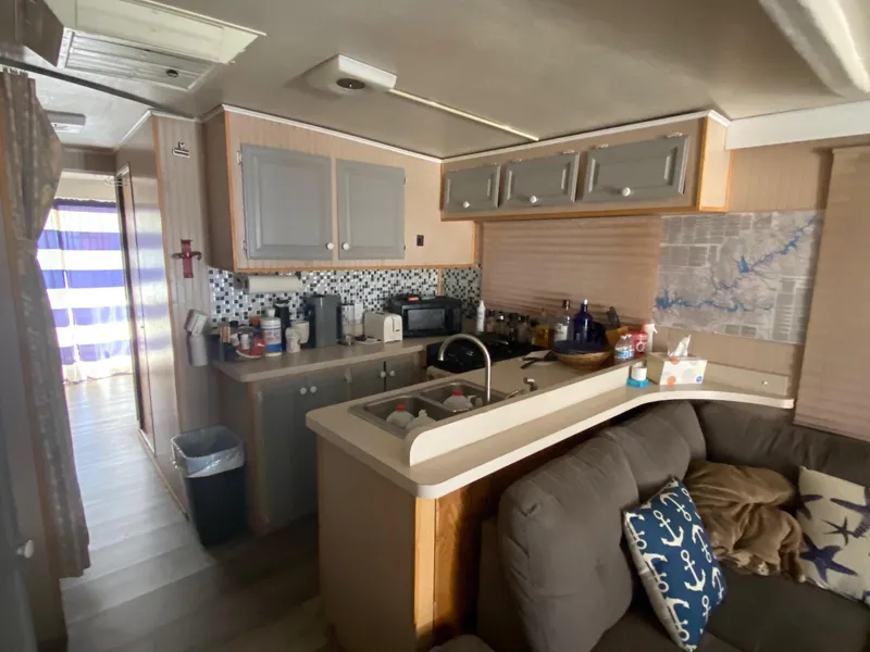 Slide: The Image of 1988 Boatel Hercules interior with kitchen, sofa, and nautical decor. - 7