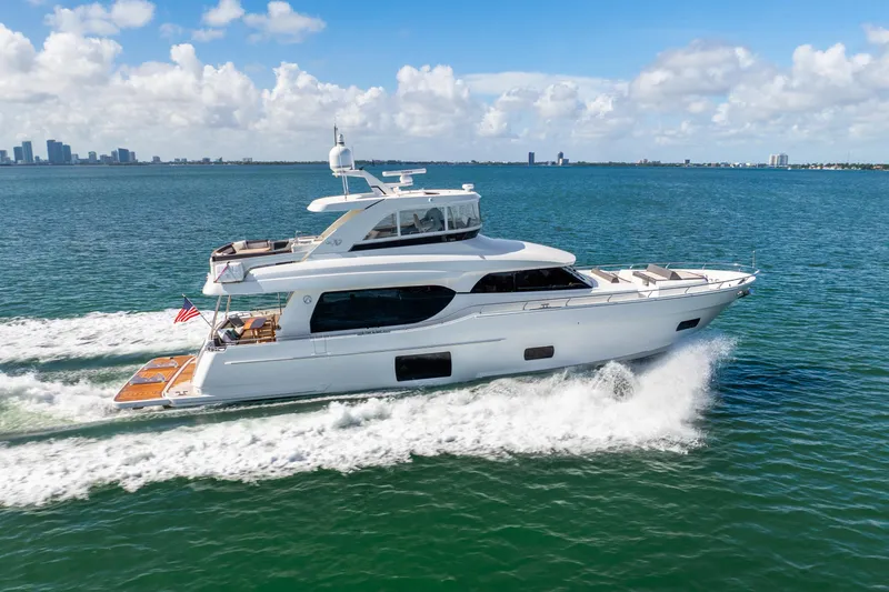 Slide: The Image of 2021 Ocean Alexander 70E Motoryacht cruising on open water under a clear blue sky. - 0