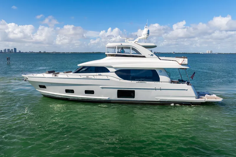 Slide: The Image of 2021 Ocean Alexander 70E Motoryacht cruising on clear blue waters. - 13