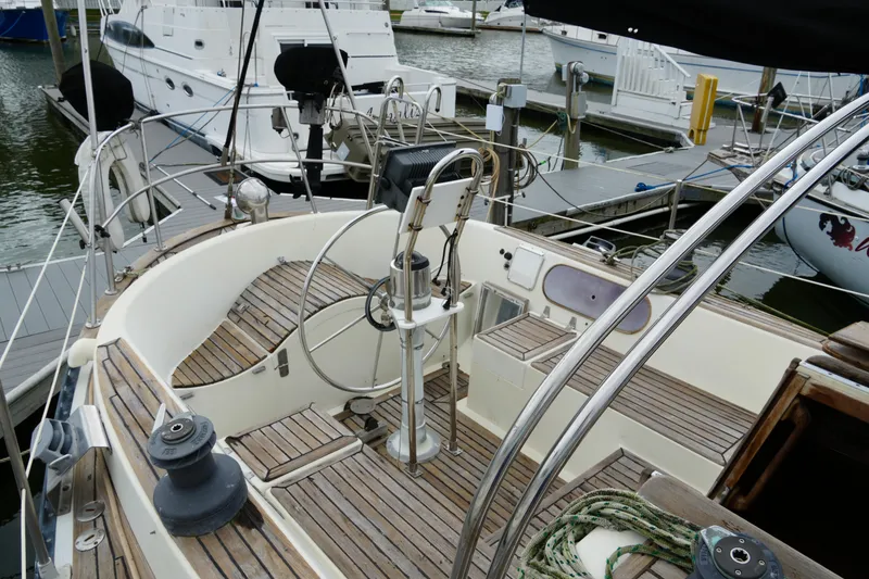 Slide: The Image of 1980 Lafitte 44 Cutter sailboat cockpit with wooden deck, docked at marina. - 12