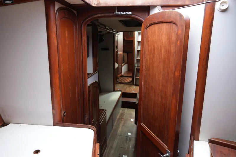 Slide: The Image of Interior of 1980 Lafitte 44 Cutter sailboat with wooden cabinetry and cozy layout. - 21
