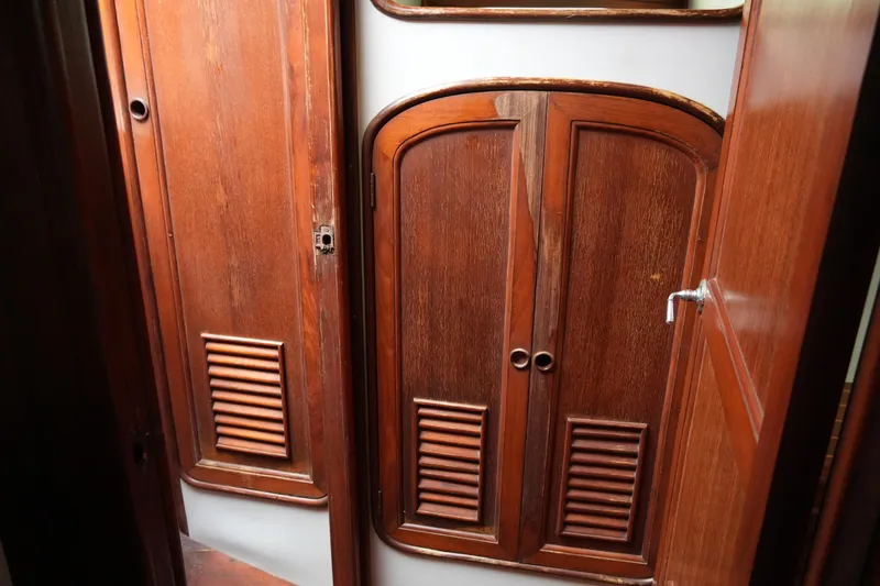 Slide: The Image of Wooden interior of 1980 Lafitte 44 Cutter sailboat, featuring elegant cabinetry and doors. - 25