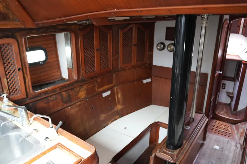 Slide: The Image of Interior of 1980 Lafitte 44 Cutter sailboat with wooden cabinetry and seating area. - 27