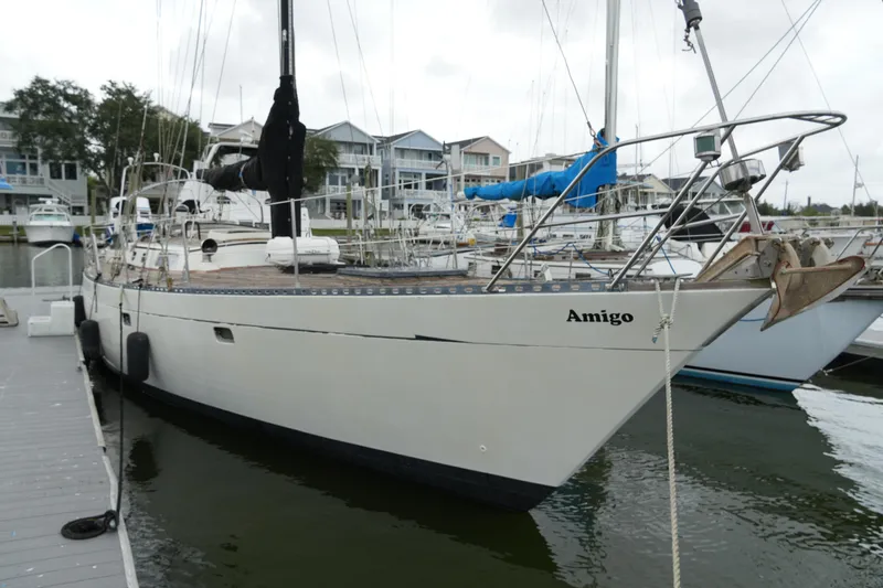 Slide: The Image of 1980 Lafitte 44 Cutter sailboat docked at marina, named "Amigo." - 3