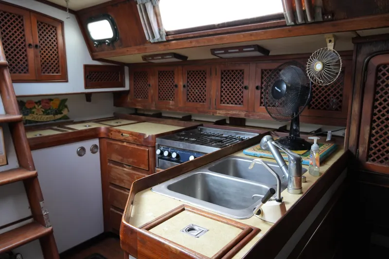 Slide: The Image of Interior of 1980 Lafitte 44 Cutter yacht kitchen with wooden cabinets and stainless steel sink. - 30