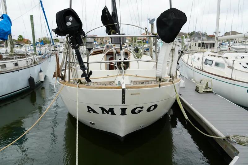 Slide: The Image of 1980 Lafitte 44 Cutter sailboat named "Amigo" docked at a marina. - 4