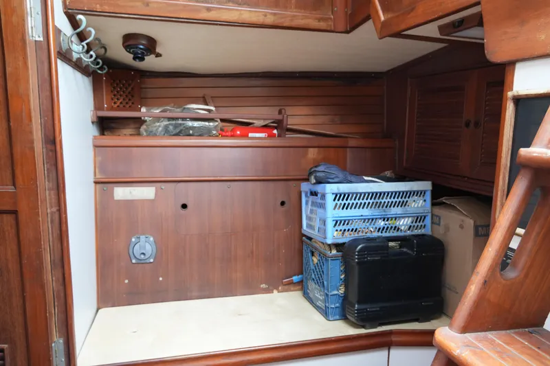 Slide: The Image of Interior storage area of a 1980 Lafitte 44 Cutter sailboat with wooden cabinetry. - 41