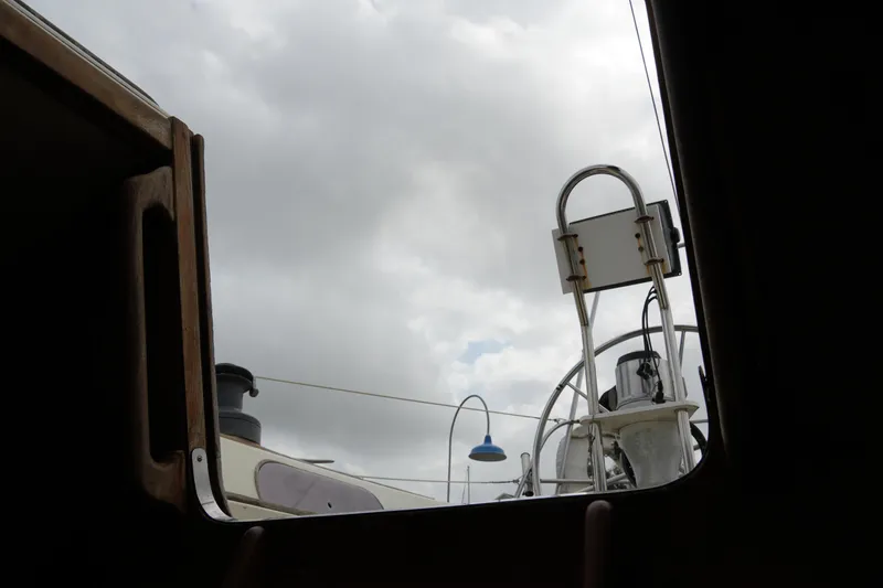 Slide: The Image of View from inside a 1980 Lafitte 44 Cutter sailboat, looking towards the deck and cloudy sky. - 42