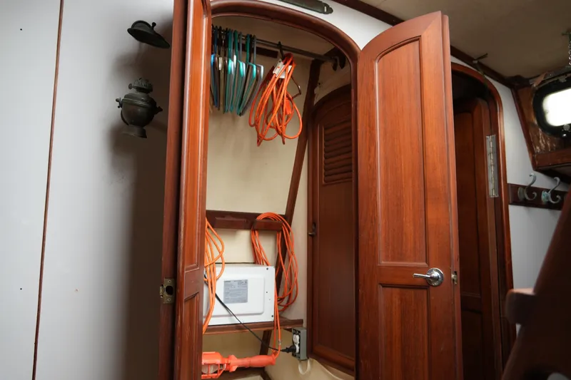 Slide: The Image of Wooden interior of 1980 Lafitte 44 Cutter sailboat with storage and electrical setup. - 43