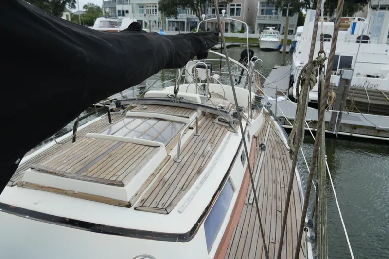 Slide: The Image of 1980 Lafitte 44 Cutter sailboat with wooden deck, docked in a marina. - 8