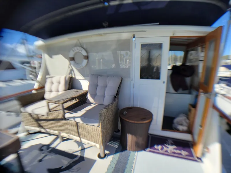 Slide: The Image of 1981 Roughwater 41 Pilot House boat interior with wicker seating and nautical decor. - 12