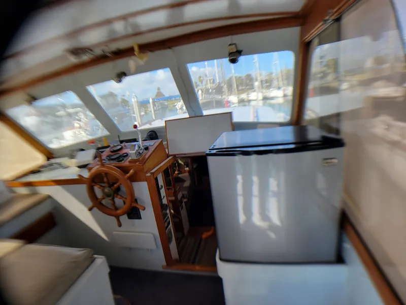 Slide: The Image of Interior of 1981 Roughwater 41 Pilot House with helm and refrigerator. - 14