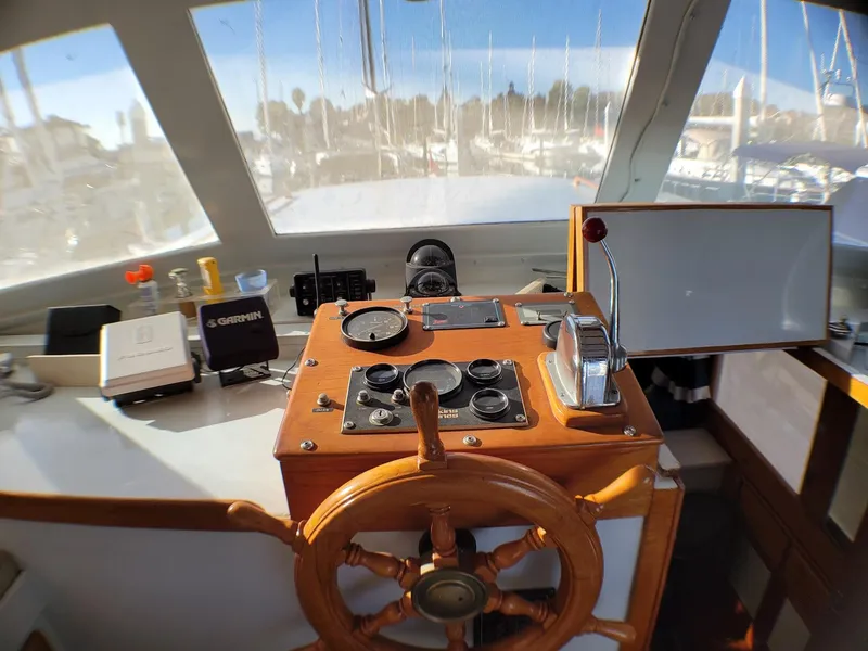 Slide: The Image of 1981 Roughwater 41 Pilot House interior with wooden steering wheel and navigation instruments. - 16