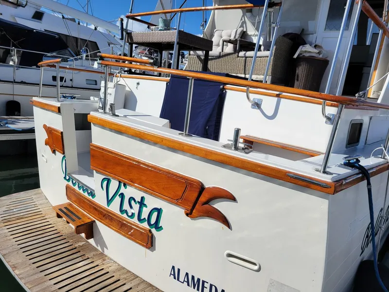 Slide: The Image of 1981 Roughwater 41 Pilot House boat docked, featuring wooden accents and "Buena Vista" lettering. - 2