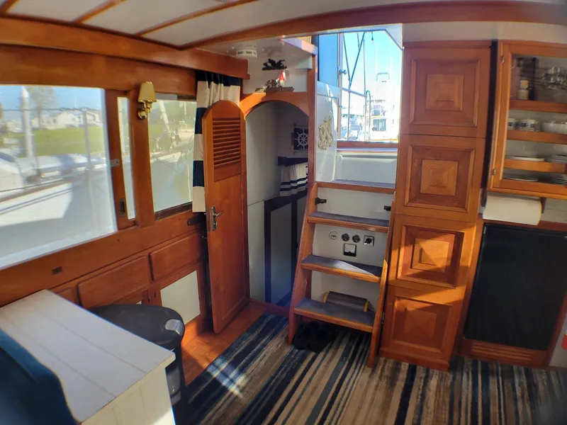 Slide: The Image of Interior of 1981 Roughwater 41 Pilot House with wooden cabinetry and striped carpet. - 24