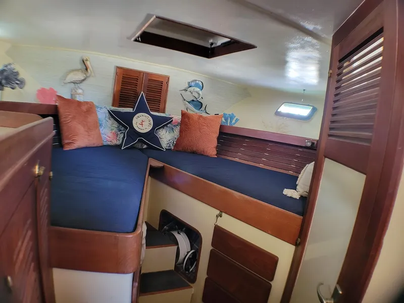 Slide: The Image of Cozy cabin interior of 1981 Roughwater 41 Pilot House with nautical decor and blue cushions. - 25