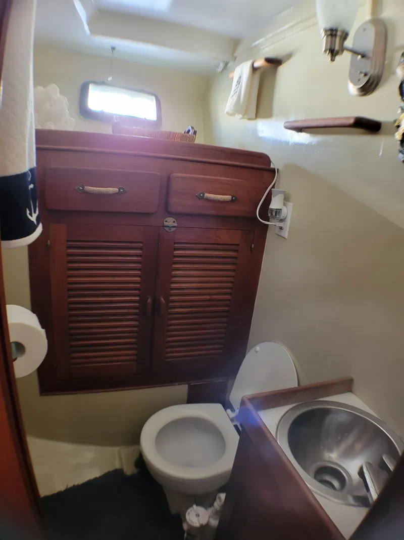 Slide: The Image of 1981 Roughwater 41 Pilot House bathroom with wooden cabinets and stainless steel sink. - 28