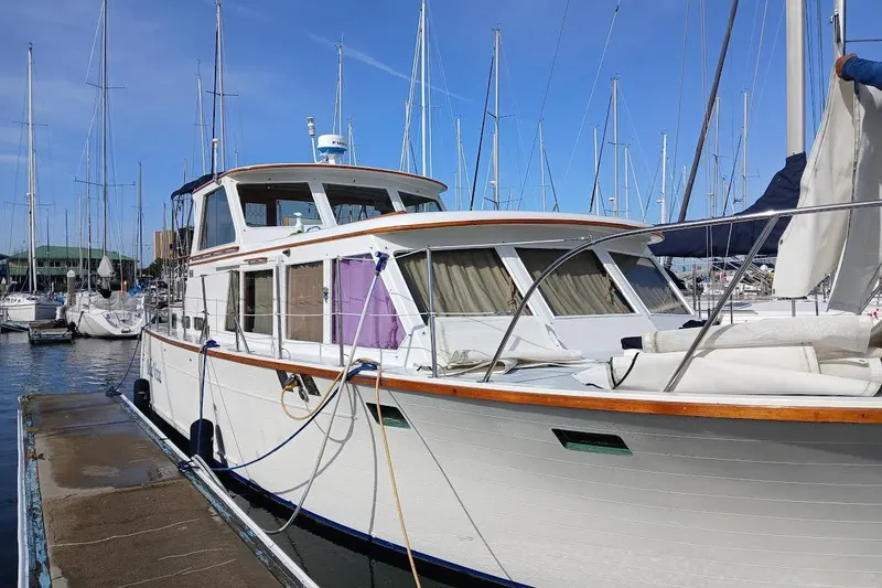 Slide: The Image of 1981 Roughwater 41 Pilot House yacht docked in a marina with sailboats. - 3