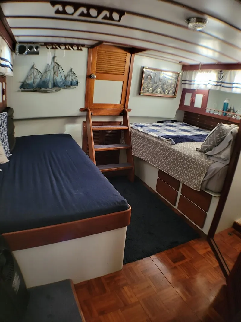 Slide: The Image of 1981 Roughwater 41 Pilot House interior with beds, wooden stairs, and nautical decor. - 31