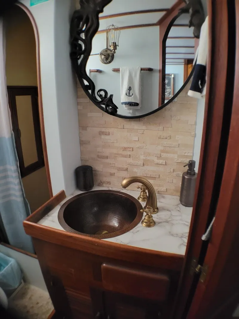 Slide: The Image of Elegant bathroom in 1981 Roughwater 41 Pilot House with brass fixtures and nautical decor. - 37