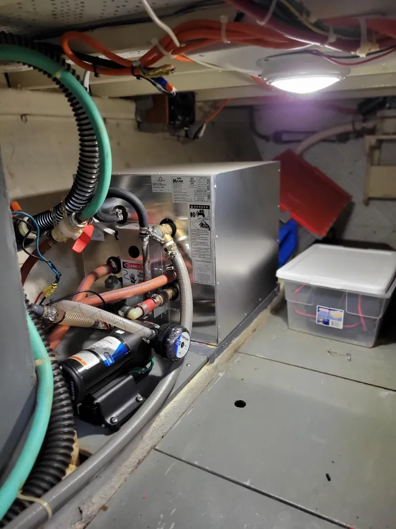 Slide: The Image of Engine room of 1981 Roughwater 41 Pilot House with mechanical components and storage box. - 43