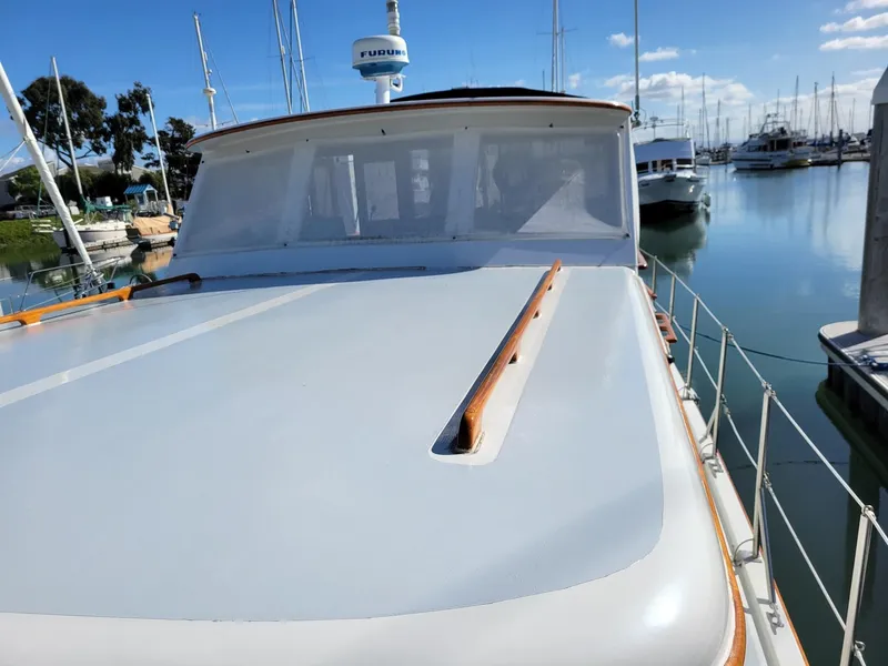 Slide: The Image of 1981 Roughwater 41 Pilot House boat docked in a marina under clear skies. - 9