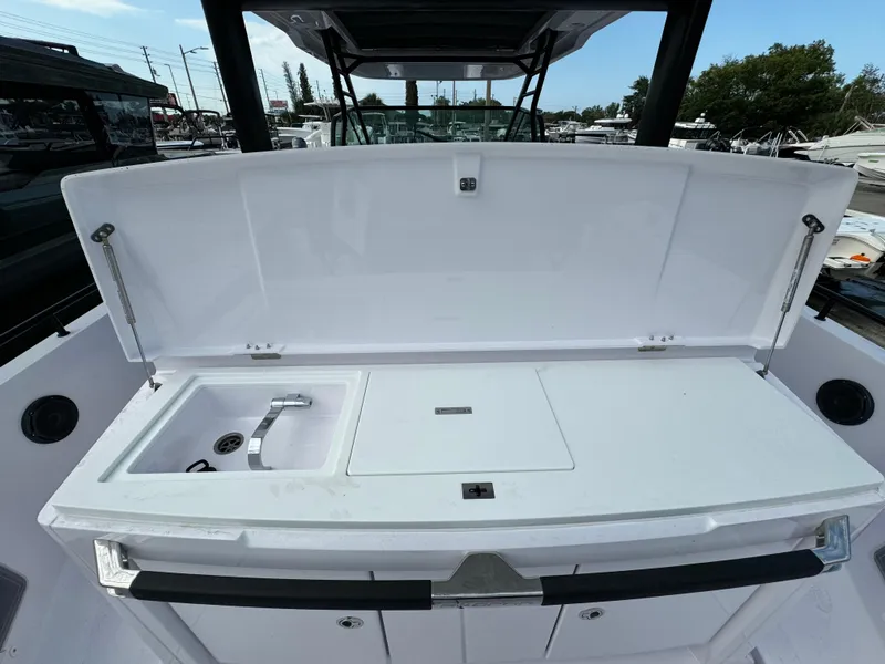 Slide: The Image of 2024 Axopar Sun Top boat with open storage compartment and sink. - 13