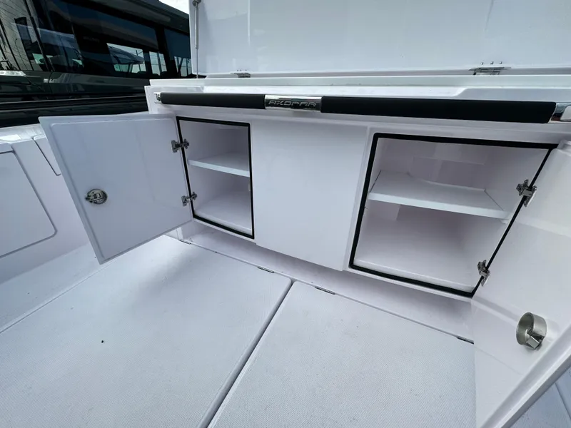Slide: The Image of 2024 Axopar Sun Top boat storage compartments with open doors. - 16