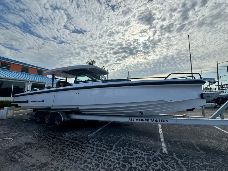 Slide: The Image of 2024 Axopar Sun Top boat on trailer under cloudy sky. - 7