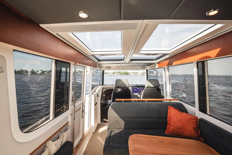 Slide: The Image of Interior of 2023 Nimbus Commuter 11 boat with panoramic windows and modern seating. - 10