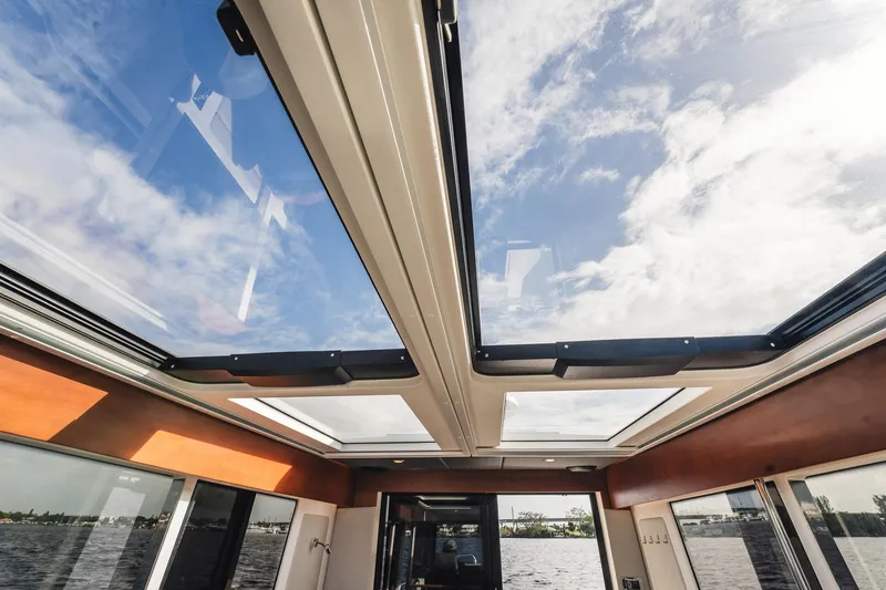 Slide: The Image of 2023 Nimbus Commuter 11 interior with panoramic sunroof and scenic water view. - 11