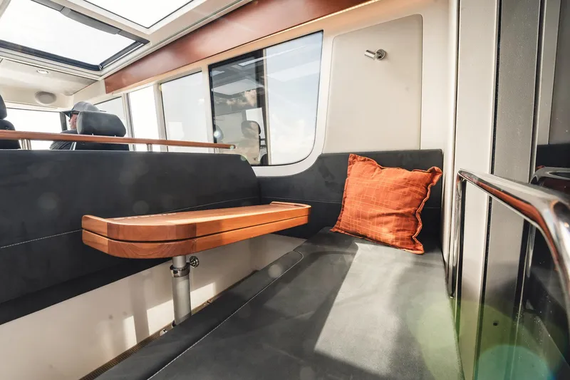 Slide: The Image of Interior of 2023 Nimbus Commuter 11 with sleek seating and wooden table. - 12