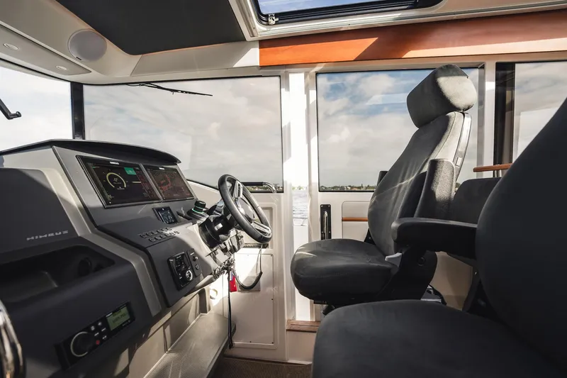Slide: The Image of Interior of 2023 Nimbus Commuter 11 boat, featuring modern dashboard and comfortable seating. - 18