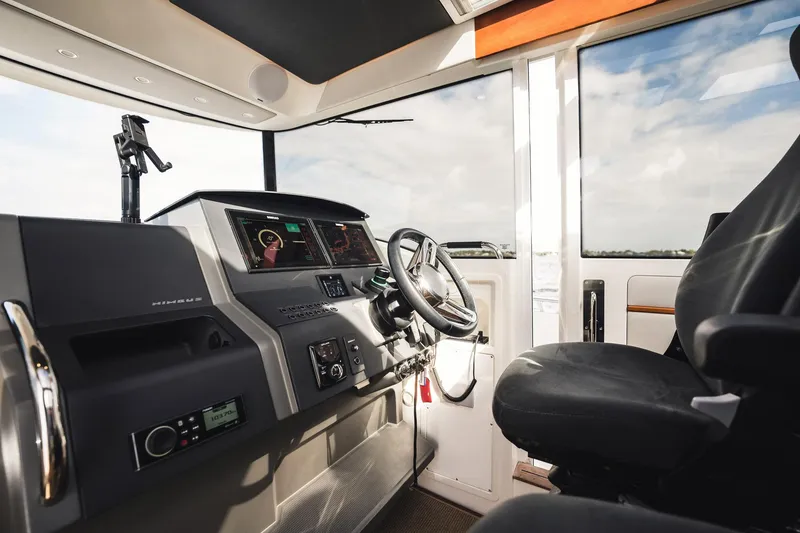 Slide: The Image of Interior of 2023 Nimbus Commuter 11 boat cockpit with steering wheel and control panel. - 19