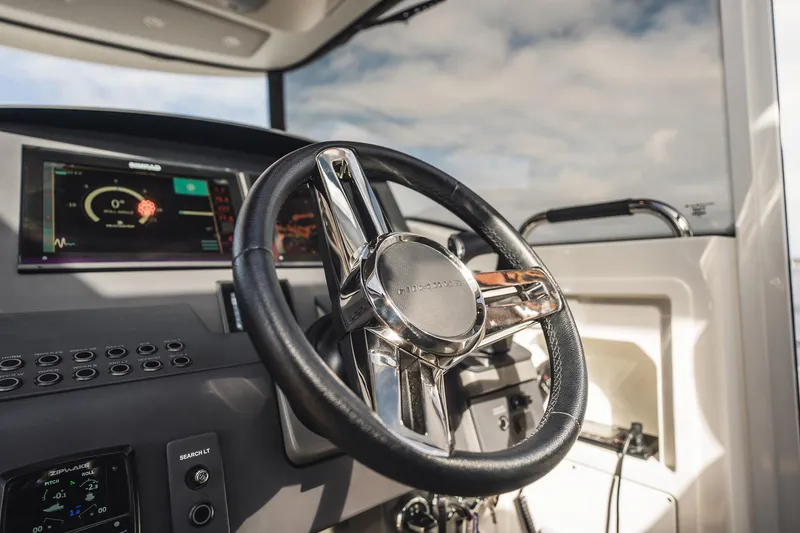 Slide: The Image of 2023 Nimbus Commuter 11 boat dashboard with modern steering wheel and digital displays. - 20