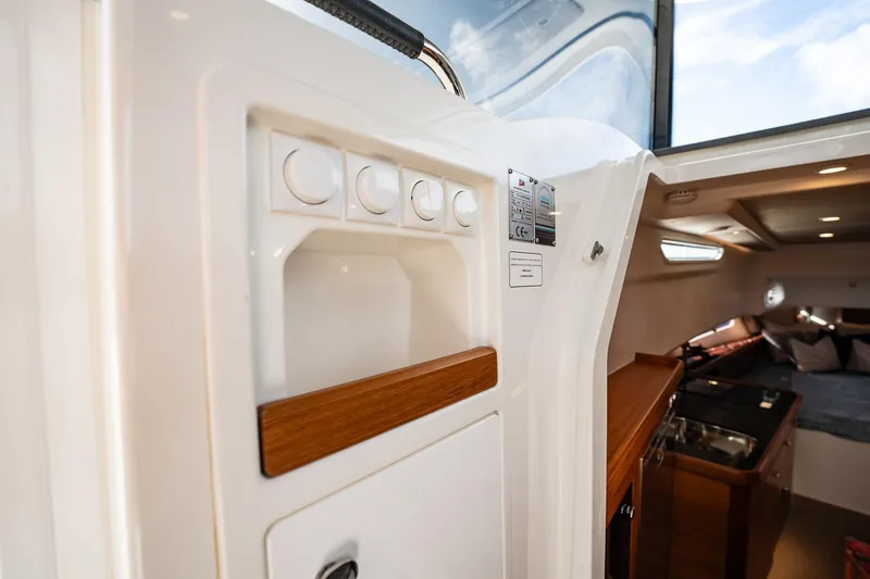Slide: The Image of Interior view of 2023 Nimbus Commuter 11 boat, featuring modern controls and cozy cabin space. - 24