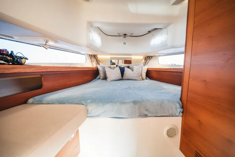 Slide: The Image of Luxurious cabin interior of 2023 Nimbus Commuter 11 with cozy bedding and wooden accents. - 31