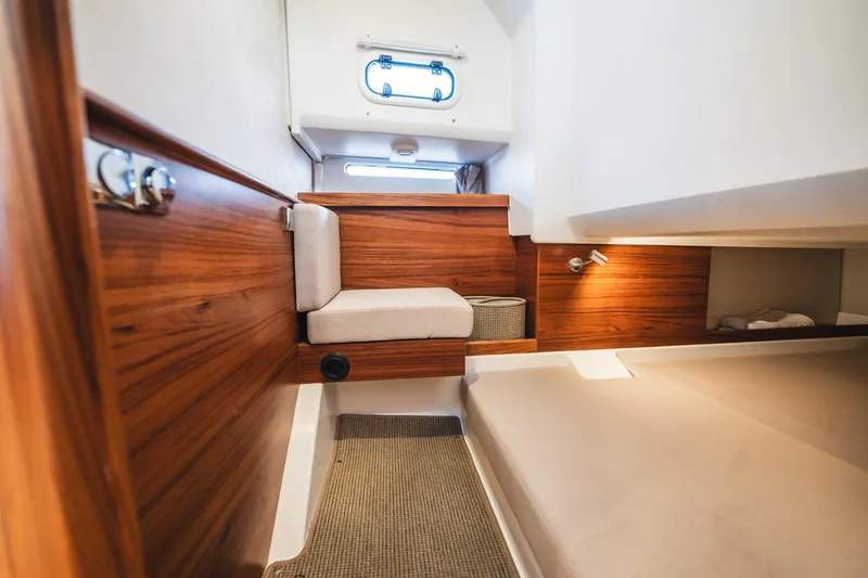 Slide: The Image of Luxurious interior of 2023 Nimbus Commuter 11 boat with wooden accents and cozy seating. - 39
