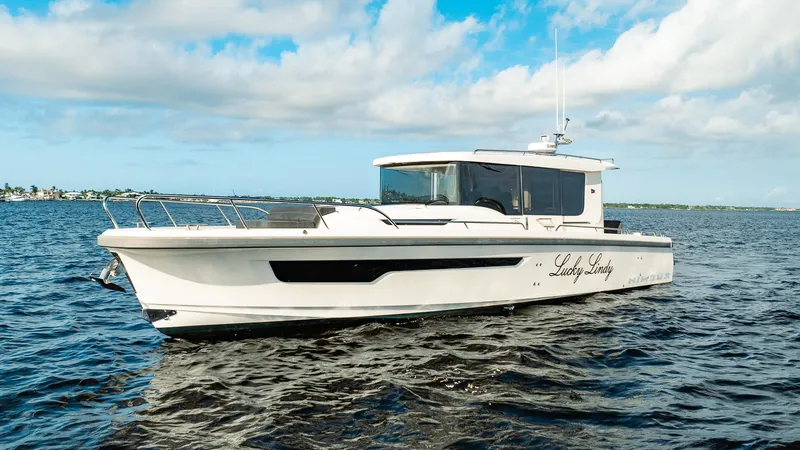 Slide: The Image of 2023 Nimbus Commuter 11 boat cruising on open water under a blue sky. - 4