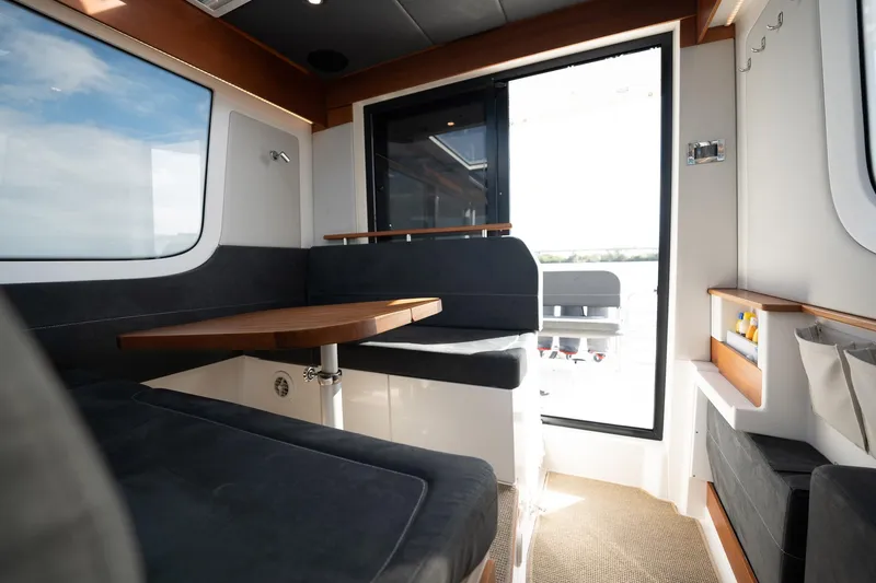 Slide: The Image of Interior of 2023 Nimbus Commuter 11 boat with modern seating and table. - 7