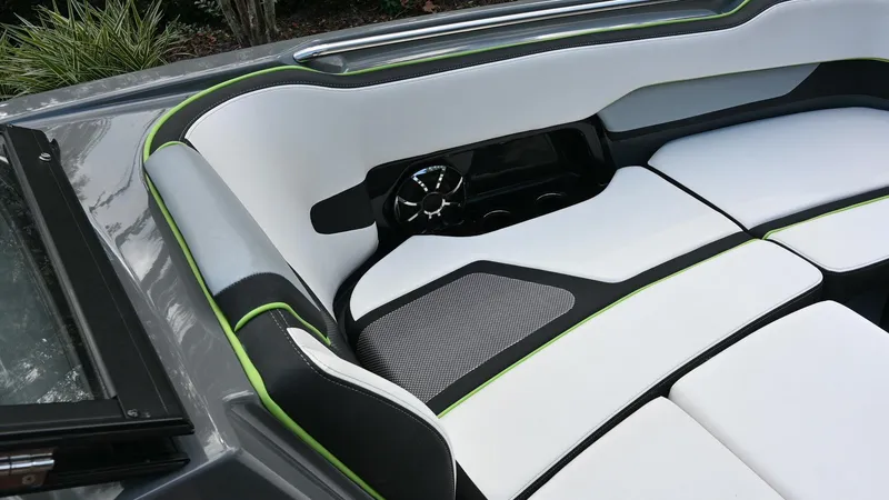 Slide: The Image of 2021 Yamaha Boats 255XD interior with sleek white and black seating, green accents. - 14