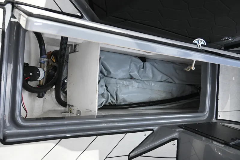 Slide: The Image of Open storage compartment in 2021 Yamaha Boats 255XD, showing interior details and equipment. - 30