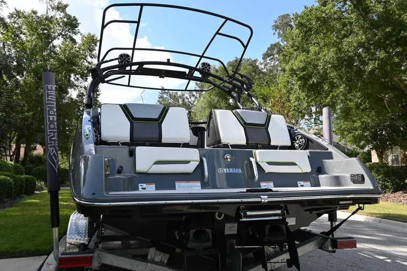 Slide: The Image of 2021 Yamaha Boats 255XD, rear view, on trailer, surrounded by trees. - 31
