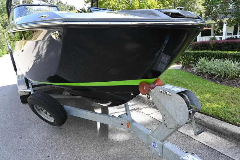 Slide: The Image of 2021 Yamaha Boats 255XD on trailer, sleek black design with green accent. - 38