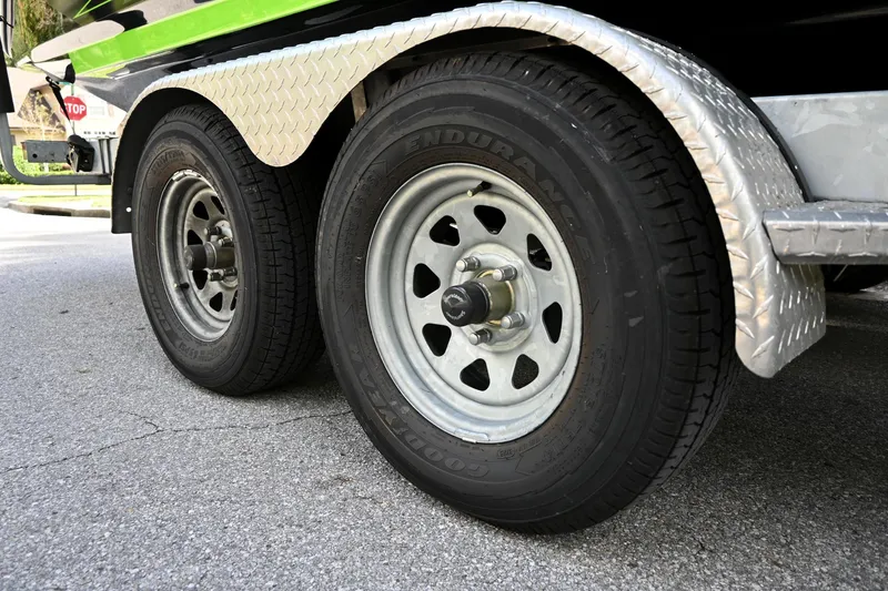 Slide: The Image of Trailer wheels of a 2021 Yamaha Boats 255XD on a paved road. - 41