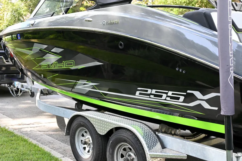 Slide: The Image of 2021 Yamaha Boats 255XD on trailer, sleek black and green design. - 45